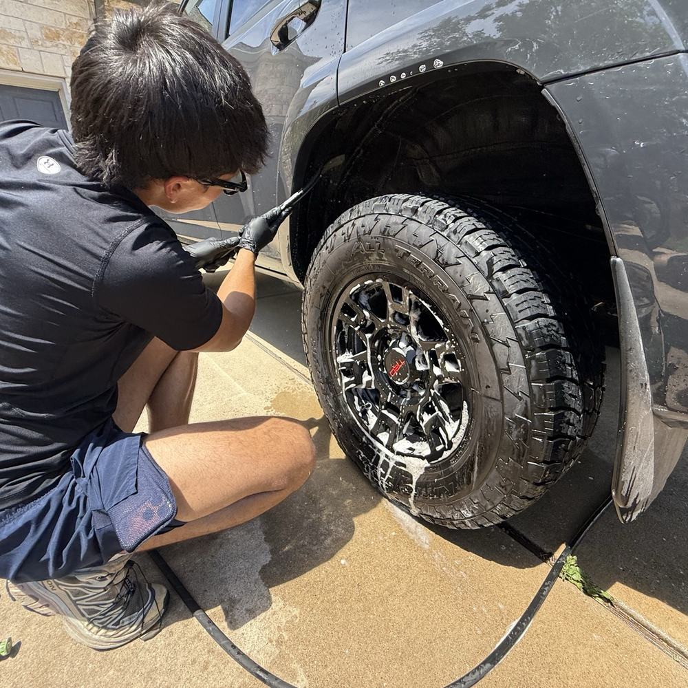 Detailer cleaning a wheel and tire